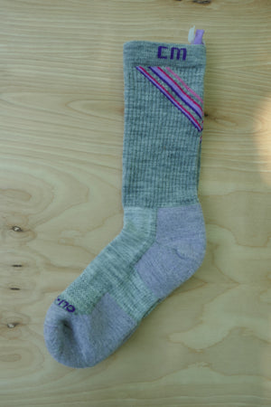 Climatesox.com E-Zmate Women's Linkable Merino Wool Light Hiking Crew Sock flat lay on natural wood surface showing light gray fabric with pink and purple chevron detail